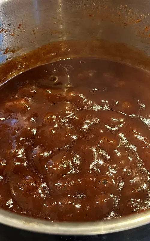 Apple cider BBQ sauce bubbling as it simmers in a pot