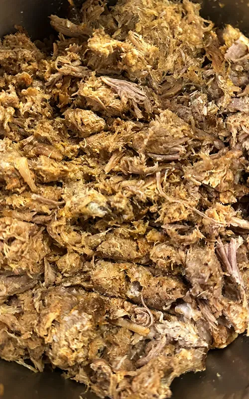 Tender pulled pork shredded in a pan
