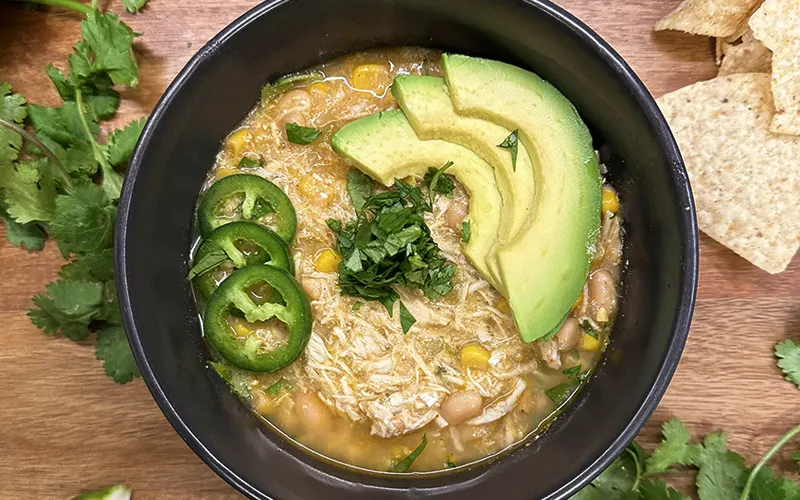 White Chicken Chili topped with jalapeño, avocado, and cilantro